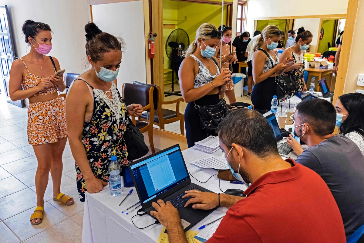People at a walk-in vaccination centre for tourists, workers and locals in the resort city of Ayia Napa, Cyprus that announced Friday its Covid-19 vaccination rollout will cover children aged 12 to 15. (AFP)