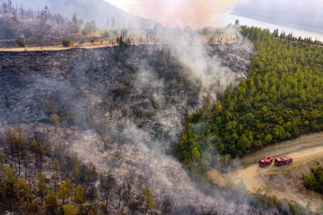 This aerial photograph shows firetrucks on a road as a wildfire which engulfed a Mediterranean resort region on Turkey's southern coast near the town of Manavgat, on July 30, 2021. (AFP)