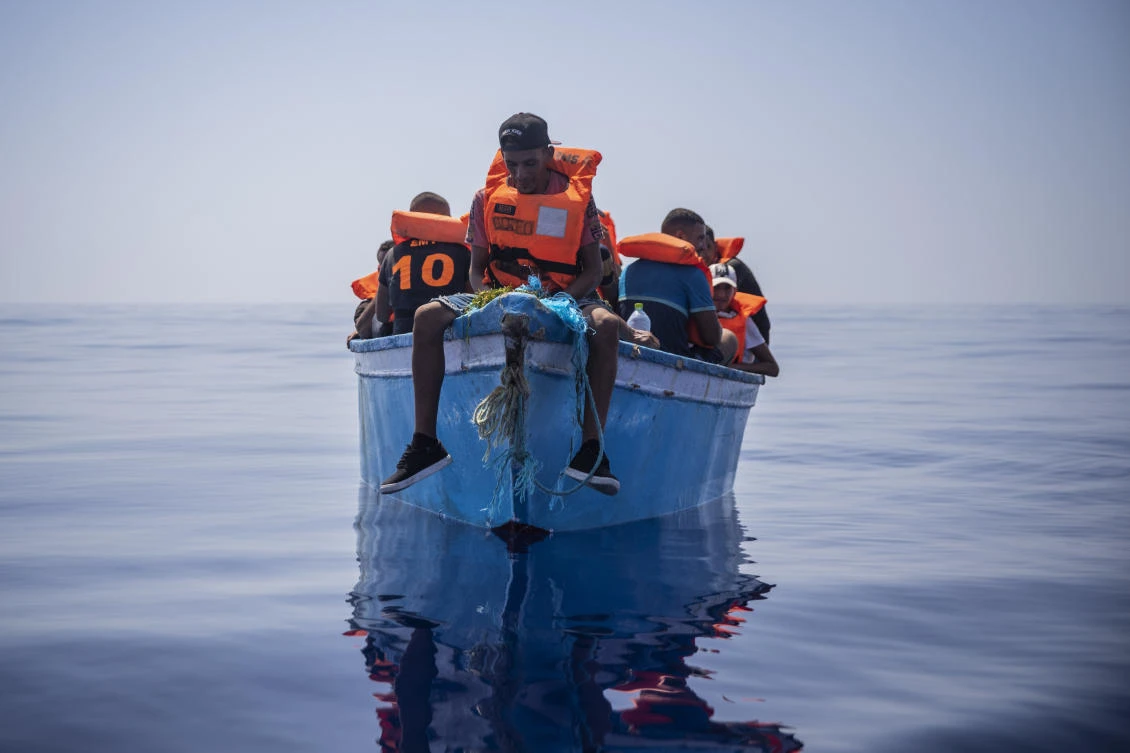 A group thought to be migrants from Tunisia aboard a precarious wooden boat wait to be assisted by a team of the Spanish NGO Open Arms, around 20 miles southwest from the Italian island of Lampedusa. (File/AP)