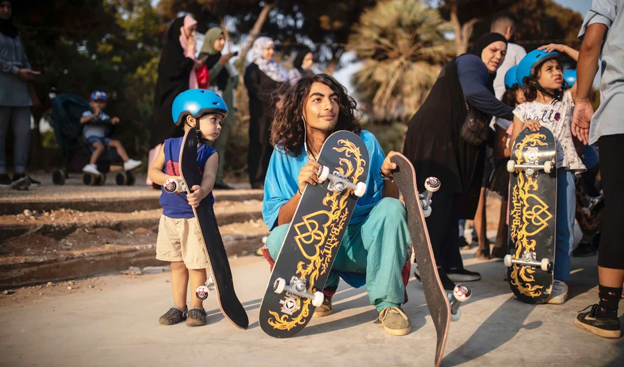 In this picture, taken on Thursday Jul.29, local skater Mike Richard is pictured holding his skateboard alongside Lebanese kids during a skateboarding lesson. (Supplied/Samantha Robison)