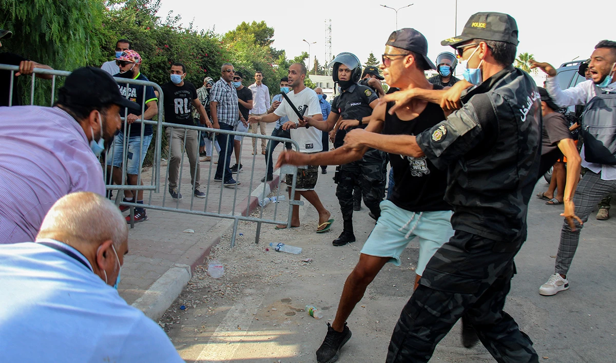 Tunisian police officers scuffle with demonstrators as they gather outside the parliament in Tunis, Tunisia, Monday, July 26, 2021. (AP)