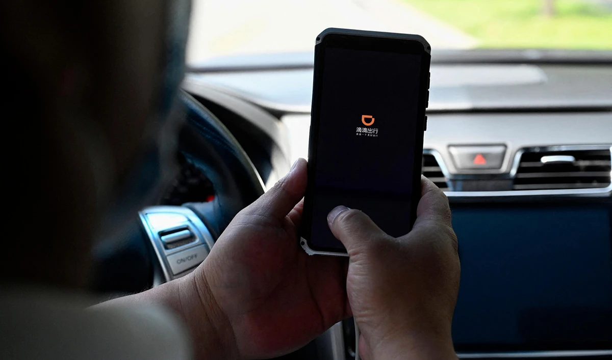 A driver opens the Didi Chuxing ride-hailing app on his smartphone in Beijing on July 2, 2021. (AFP)