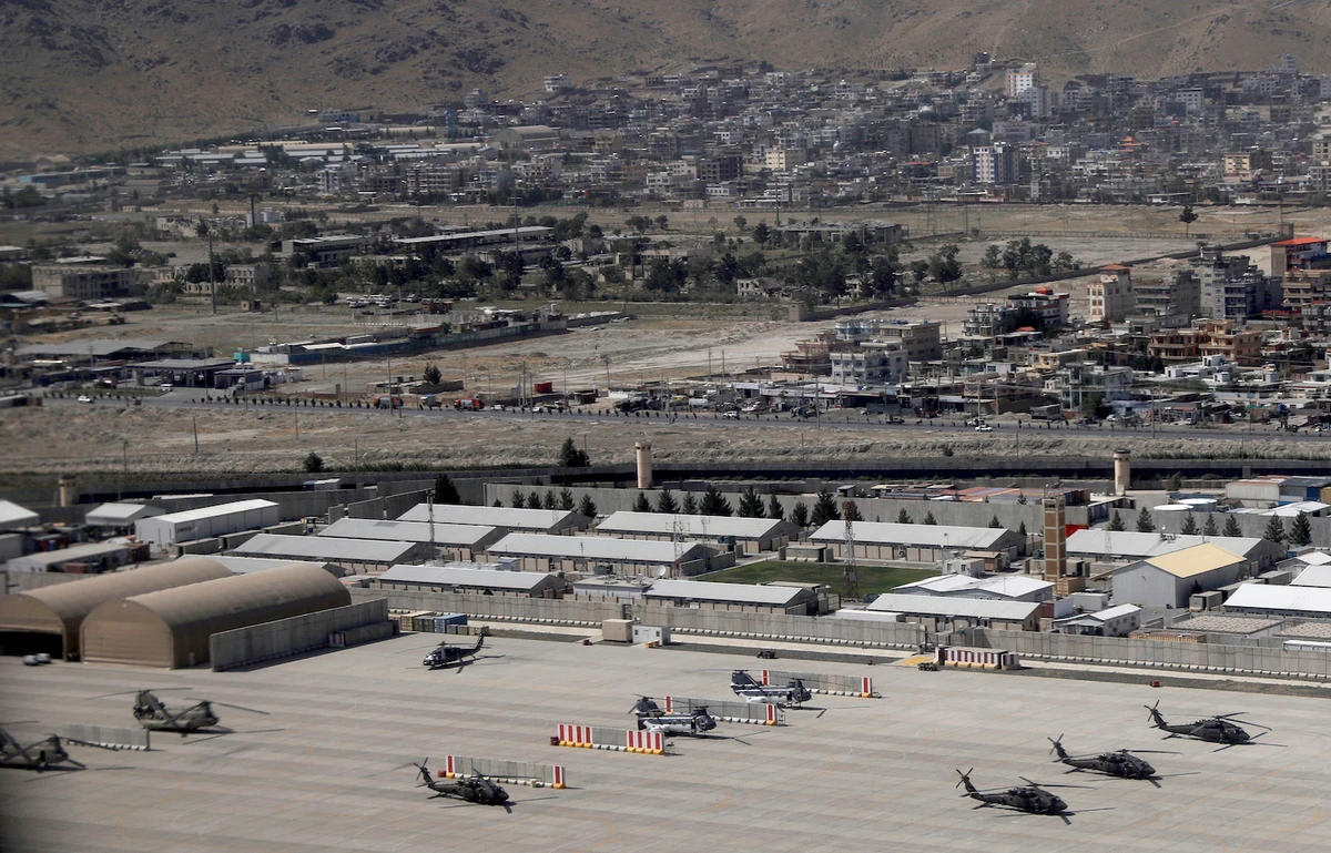 Kabul Military Airport where helicopters are parked are shown through a window of a commercial airplane. (File/AP)