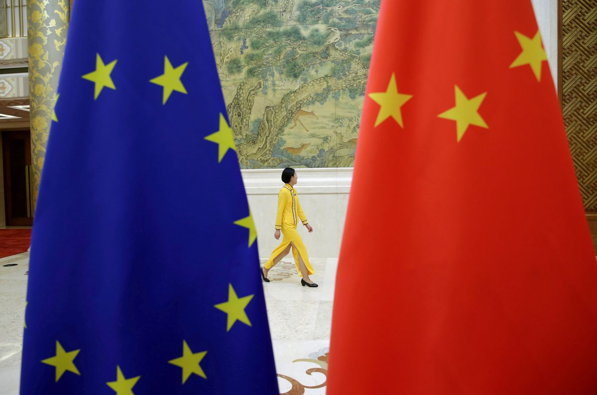 An attendant walks past EU and China flags ahead of the EU-China High-level Economic Dialogue, Diaoyutai State Guesthouse, Jun. 25, 2018. (Reuters)