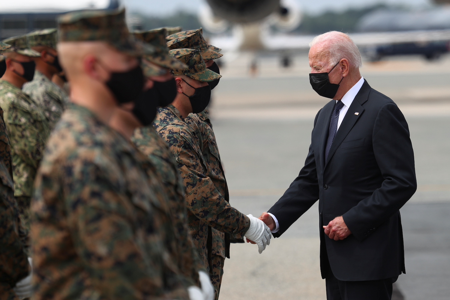 US President Joe Biden shakes hands with a member of the US Marine Corps Honor Guard in Dover, Delaware, August 29, 2021. (Reuters)
