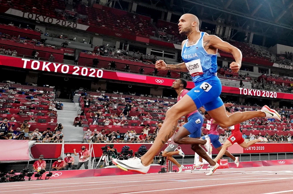 Lamont Marcell Jacobs of Italy crosses the finish line and wins gold. (Reuters)