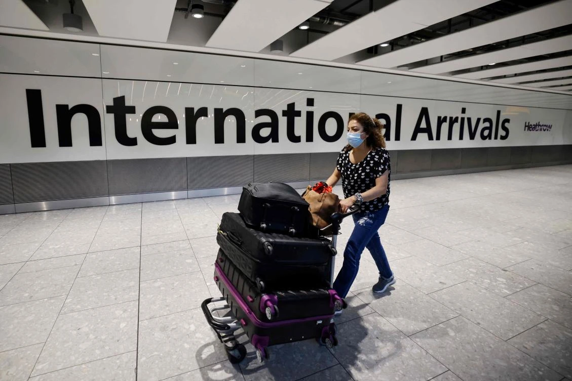 Travelers arrive at Heathrow’s Terminal 5 in west London on Monday. British Prime Minister Boris Johnson said he wanted to get the travel industry moving again with a simple user-friendly system. (AFP)
