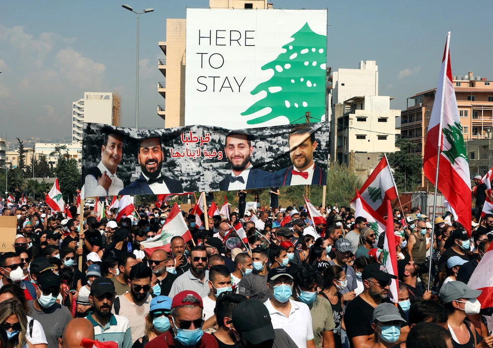 People carry national flags and pictures of some of the victims of last year’s Beirut port blast, as Lebanon marks the one-year anniversary of the explosion in Beirut, Lebanon, Aug. 4, 2021. (Reuters)