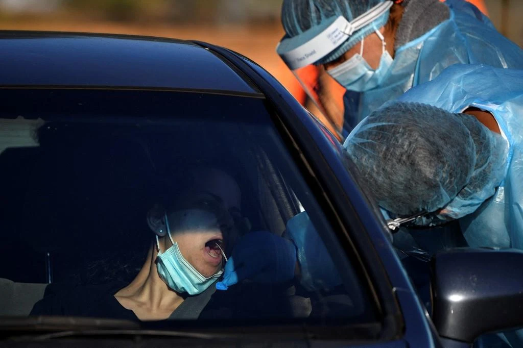 A health worker takes a swab sample from a resident at a COVID-19 drive-through testing site in western Sydney on Aug. 4, 2021. (AFP)