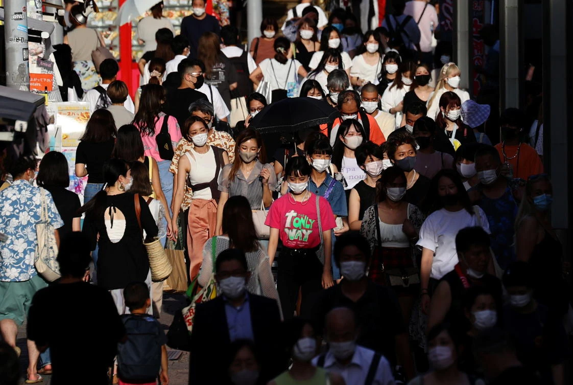 People wearing protective masks, amid COVID-19 outbreak make their way at a shopping district in Tokyo. Prime Minister Yosihide Suga told reporters Thursday there is no evidence linking the increase in cases to the July 23-Aug. 8 Games. (Reuters)