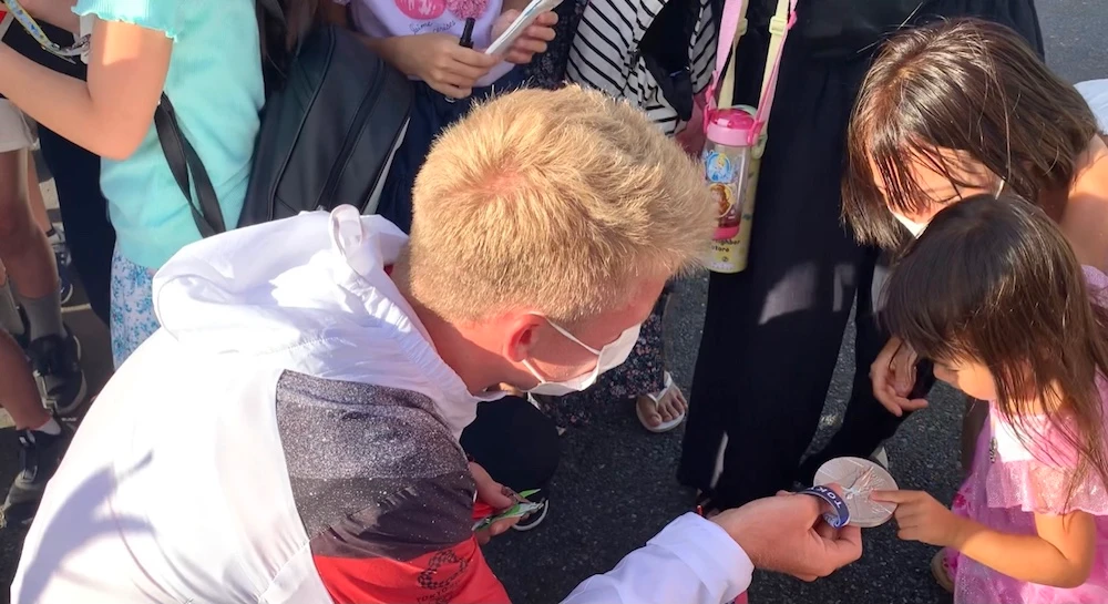 Kids enjoy interaction with athletes at entrance to Olympic Village