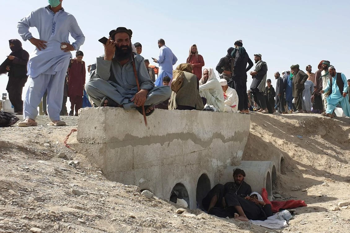Stranded people wait for the reopening of the border crossing point which was closed by the authorities, in Chaman on August 7, 2021, after the Taliban took control of the Afghan border town in a rapid offensive across the country. (AFP)