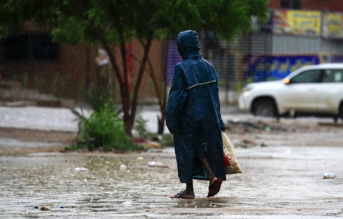 A woman walks along a flooded street in Khartoum after torrential rain fell on the Sudanese capital, almost paralising traffic, on August 8, 2021. (File/AFP)