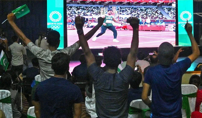 Supporters of Pakistan athlete Arshad Nadeem watch the Tokyo 2020 Olympic Games on a screen as he competes in the men's javelin throw final, in Lahore. (AFP)