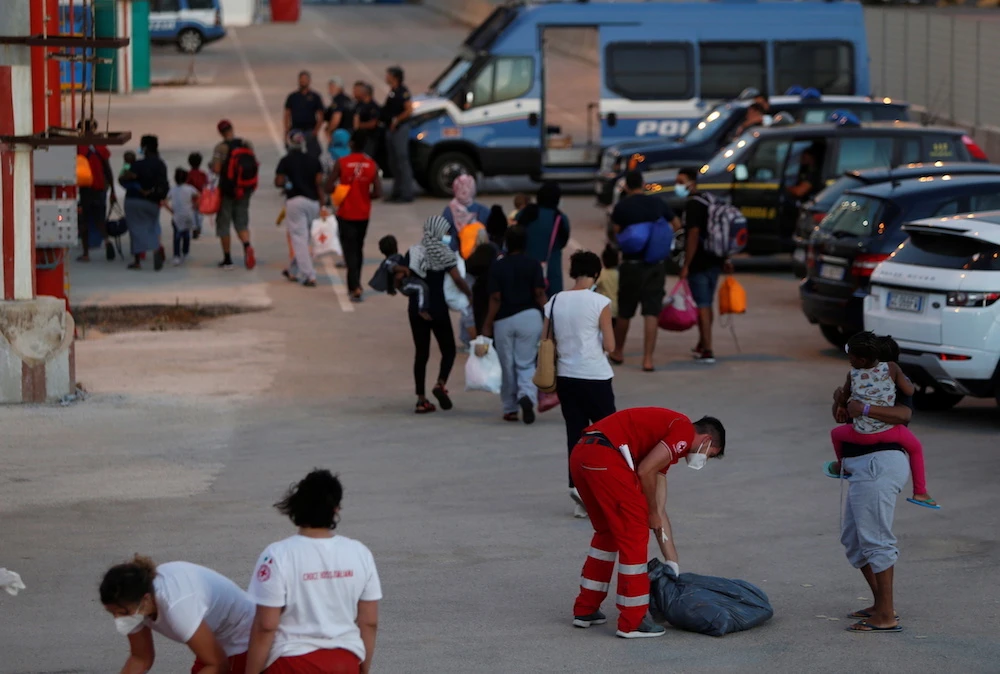 Migrants walk away from the German NGO migrant rescue ship Sea-Watch 3 after it docked with 257 rescued migrants at Trapani on the island of Sicily, Italy, August 7, 2021. (Reuters)