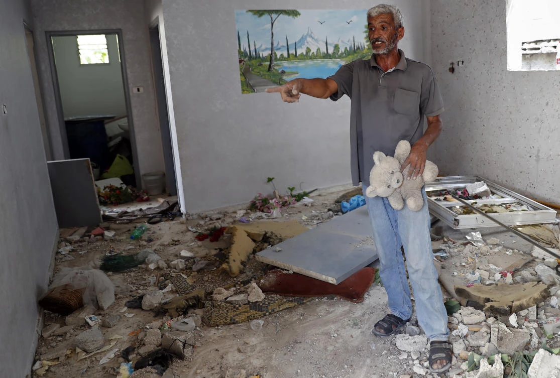 Nasser Abu Fares, who lost three daughters and a grandson when an Israeli artillery bombardment hit his family house during the 11-day war between Israel and Gaza’s Hamas rulers in May, holds his daughter’s teddy bear. (AP)