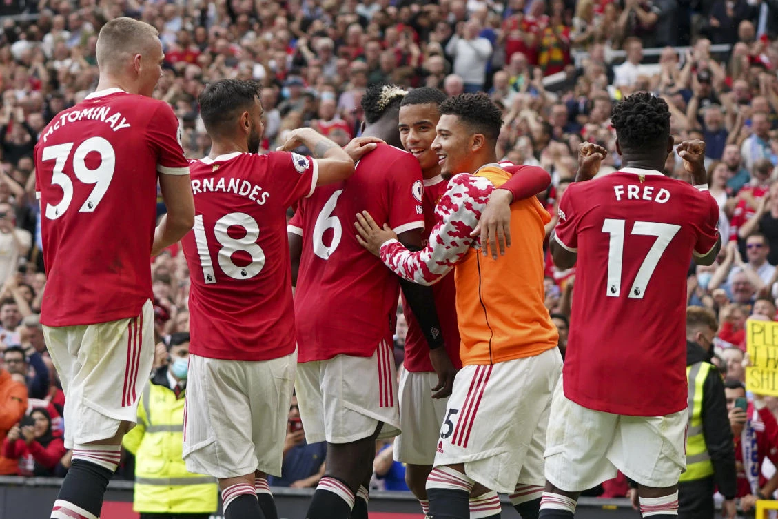 Manchester United’s Paul Pogba celebrates with his teammates after United’s Fred scored their fifth goal during the English Premier League match between United and Leeds United at Old Trafford on Saturday. (AP)
