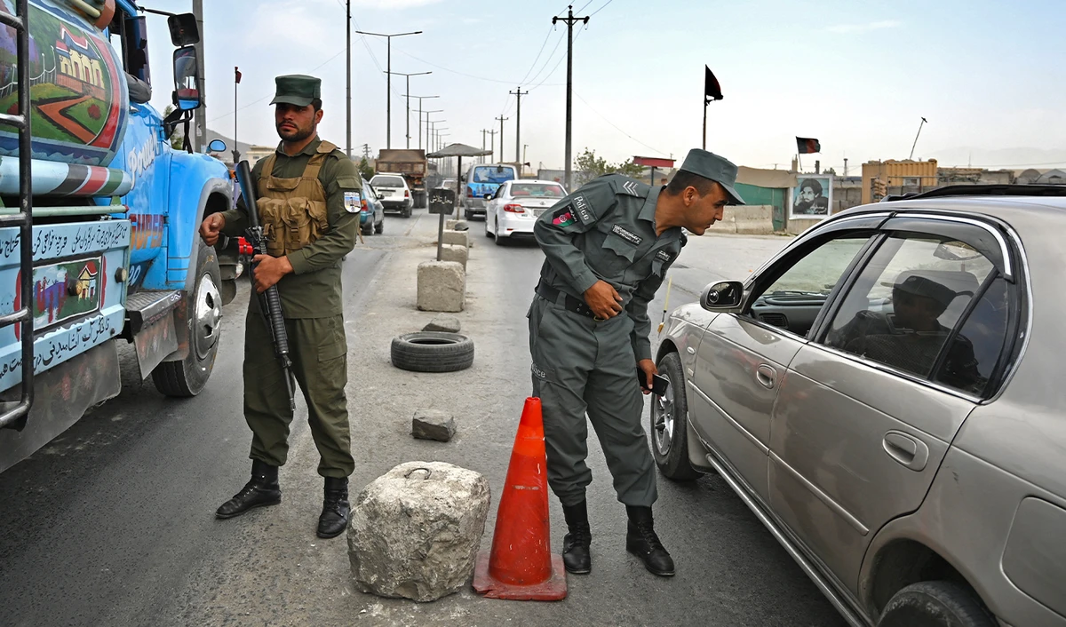 Afghan policemen stand guard at a checkpoint along the road in Kabul. Afghanistan, on August 14, 2021. (AFP)