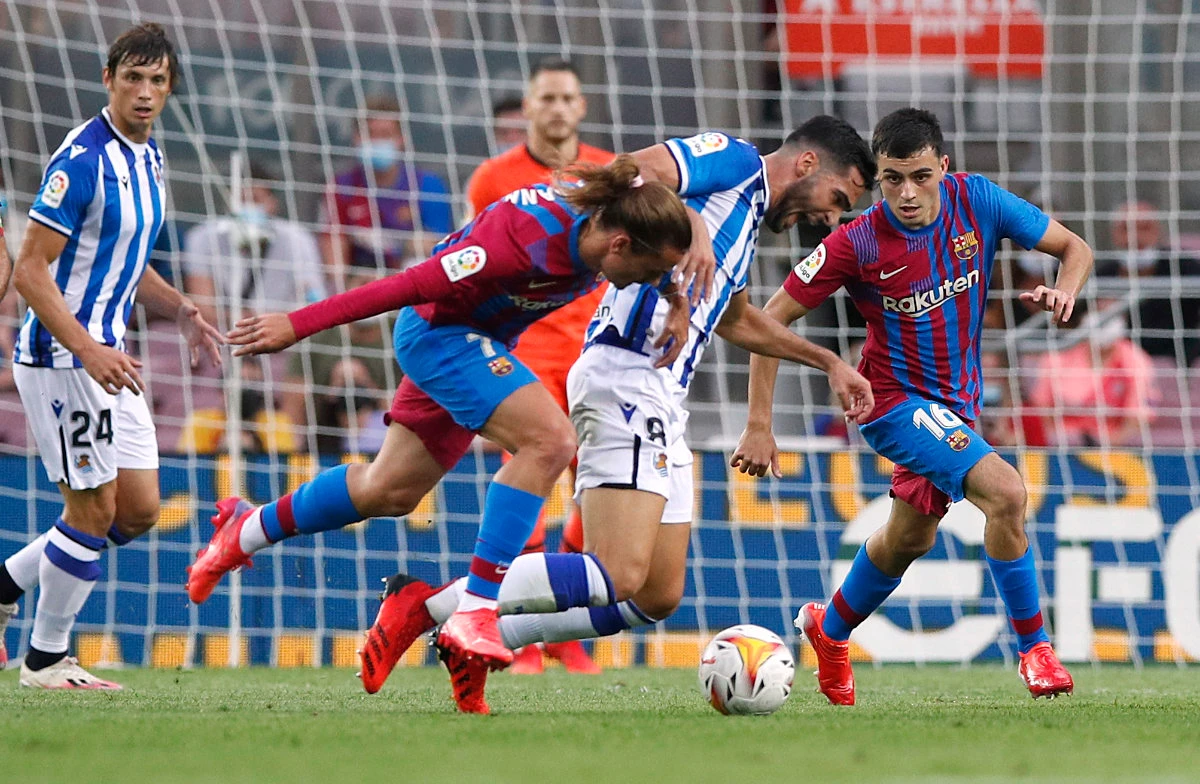Barcelona's Antoine Griezmann in action with Real Sociedad's Mikel Merino on August 15, 2021. (REUTERS/Albert Gea)