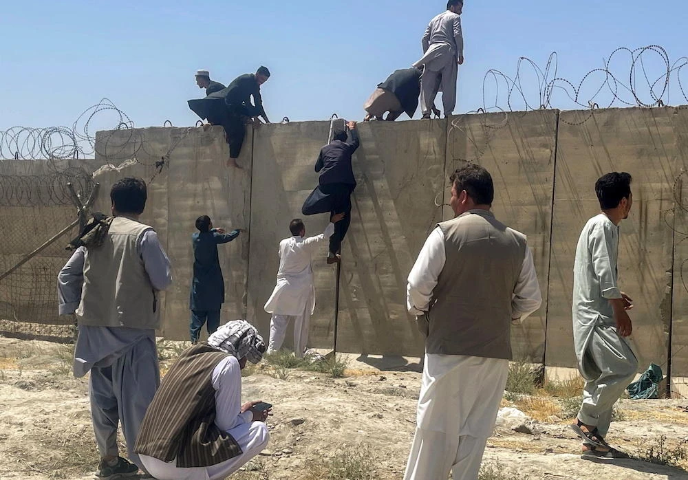 Men try to get inside Hamid Karzai International Airport in Kabul, Afghanistan, August 16, 2021. (Reuters)