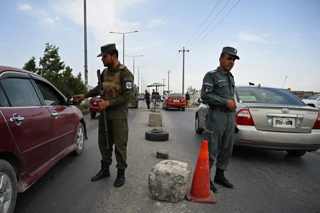 The Taliban Tuesday declared a general amnesty for all government officials and urged them to return to work. Above, Afghan policemen stand guard at a checkpoint along the road in Kabul on Aug. 14, 2021. (AFP)