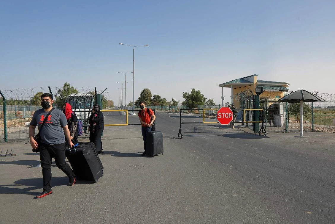 People pass through a police checkpoint, two kilometers from ‘Friendship Bridge’ on the Uzbekistan and Afghanistan border, near Termez, on August 14, 2021. (AFP)