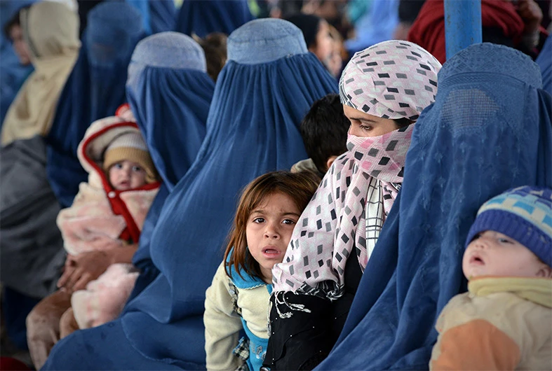 Afghan women and their children sit at The United Nations High Commissioner for Refugees (UNHCR) repatriation center on the outskirts of Peshawar on February 2, 2015.(AFP)