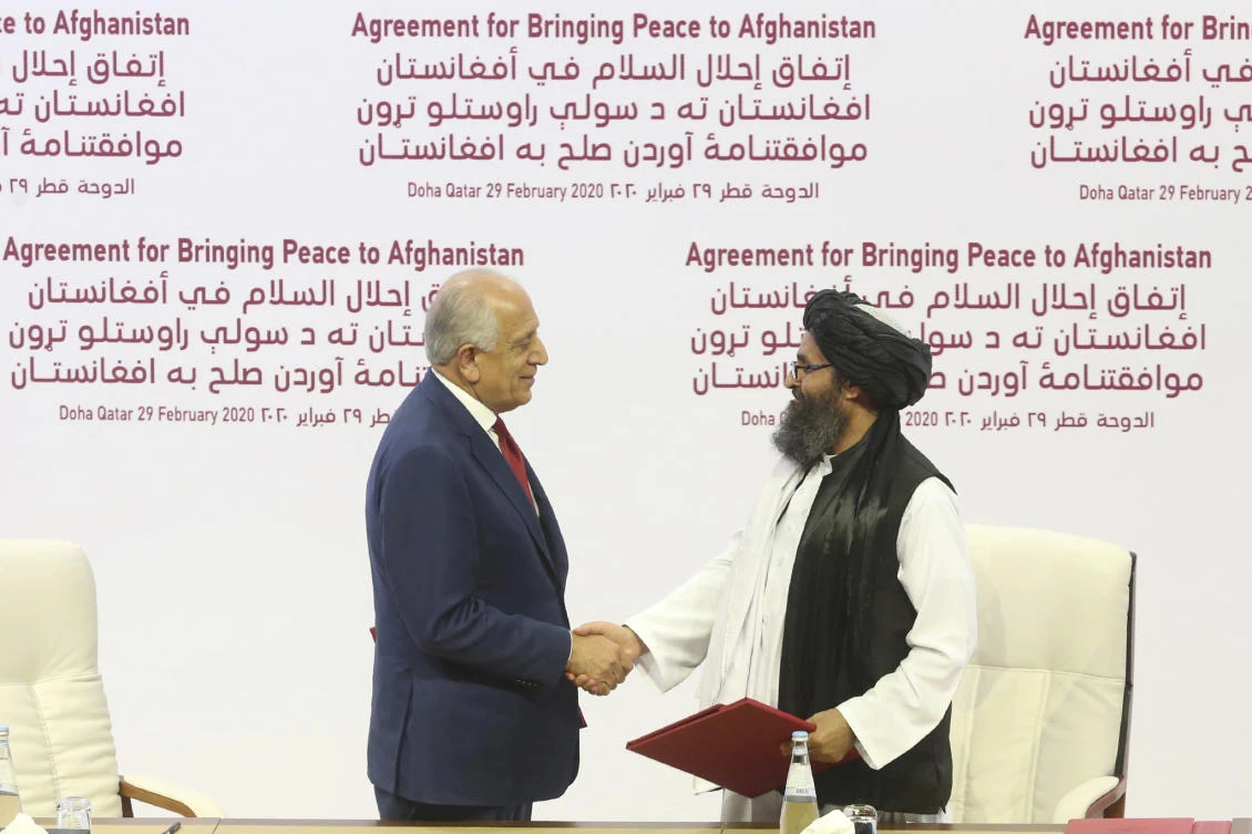 US peace envoy Zalmay Khalilzad (L) and Mullah Abdul Ghani Baradar (R), the Taliban's top political leader, shake hands after signing a peace agreement between Taliban and US officials in Doha, Qatar on Feb. 29, 2020. (File/AP)