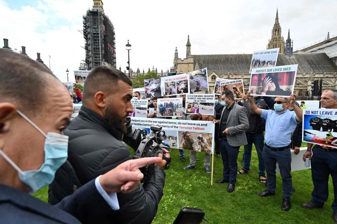 Demonstrators, including former interpreters for the British Army in Afghanistan, hold placards as they protest opposite the Houses of Parliament in London on Wednesday following the resumption of power by the Taliban in Kabul. (AFP)