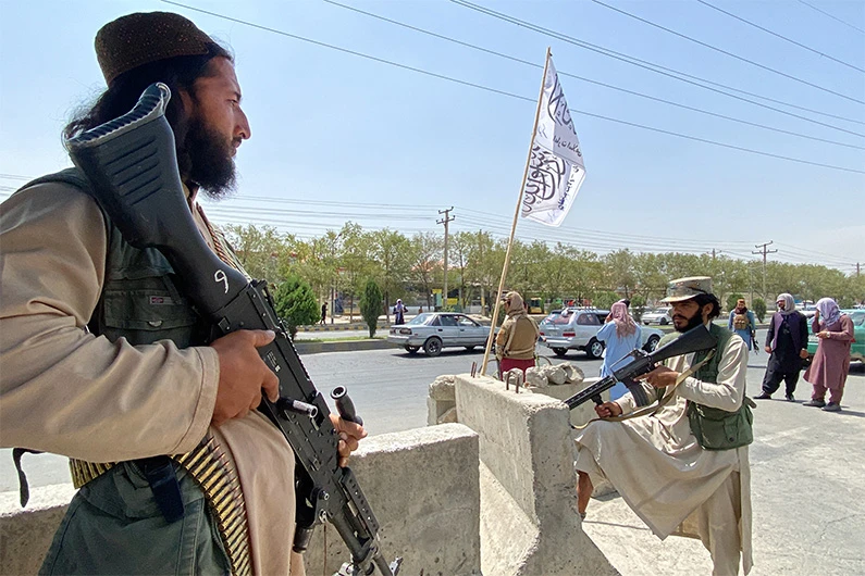 Taliban fighters stand guard at an entrance gate outside the Interior Ministry in Kabul on August 17, 2021. (AFP)