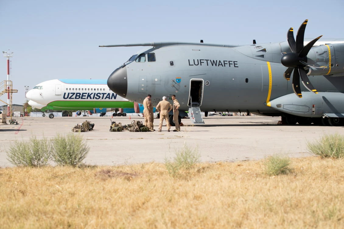 An image taken for staff talking near Airbus A400 transport aircraft of German Air Force Luftwaffe in Tashkent on Wednesday. Uzbekistan sent 150 Afghan refugees back to Afghanistan, after agreeing with Taliban based on refugees’ requests. (Reuters)