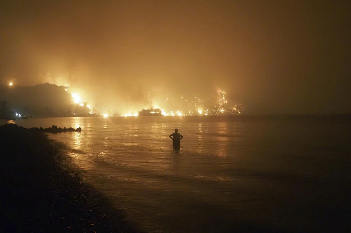 Wildfires approaching Kochyli beach near Limni on the Greek island of Evia on Aug. 6. Fire Department said by Friday evening 461 firefighters, 166 vehicles, 10 water-dropping planes and 18 helicopters were fighting the blaze. (AP)