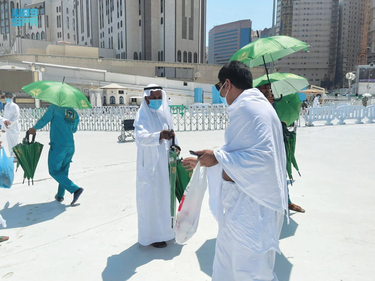 A worker at the Grand Mosque in Makkah distributes umbrellas to worshippers for protection from the scorching heat of the sun. (SPA)