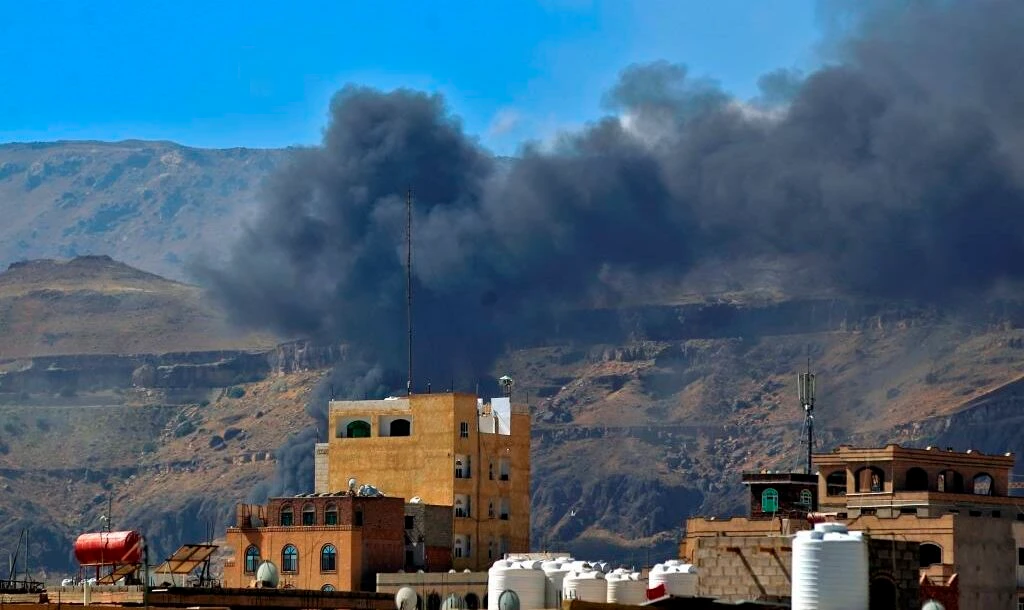 Smoke billows following an Arab coalition airstrike in the Yemeni capital Sanaa, November 27, 2020. (AFP)
