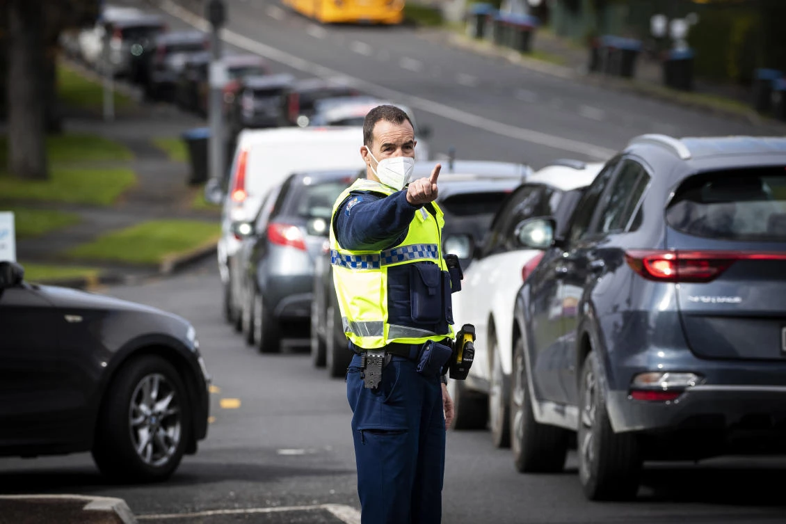 New Zealand’s vaccination pace was the slowest among the wealthy nations of the OECD grouping. Above, police control the long vehicle line waiting for COVID-19 testing in Auckland. (New Zealand Herald via AP)