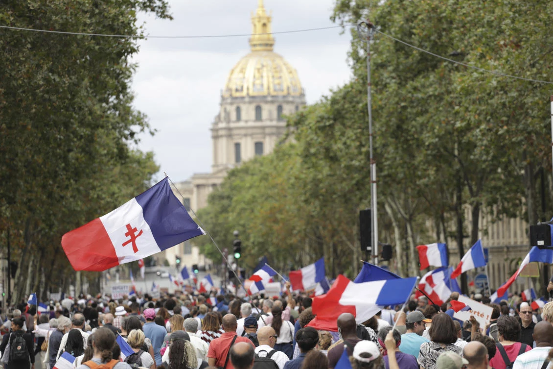 Demonstrators march during a far-right rally against the health pass on Saturday in Paris. People denounce a COVID-19 health pass needed to access restaurant, long-distance trains and other venues. (AP)