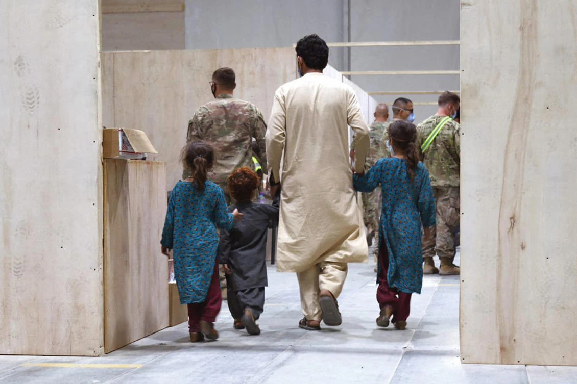 This handout image provided by the US Embassy in Kuwait on Tuesday shows US Air Force personnel escorting “at-risk Afghan evacuees” at an unspecified coalition military installation in Kuwait. (AFP)