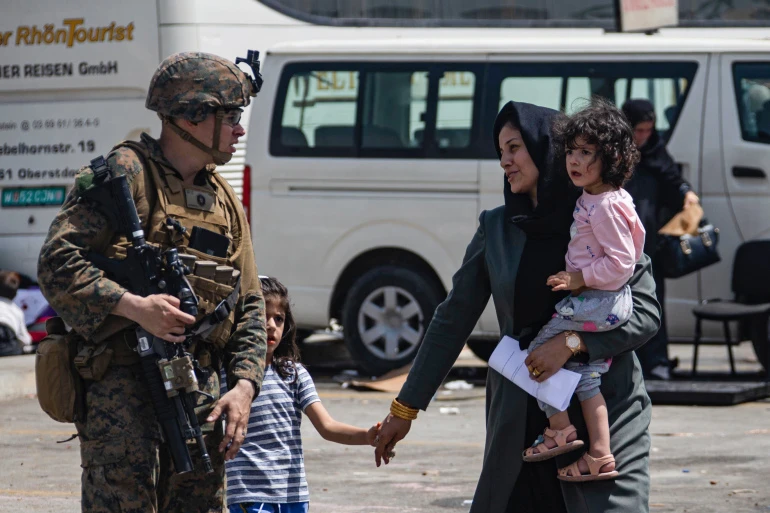 A US Marine escorts evacuees at Hamid Karzai International Airport, in Kabul, Afghanistan, Friday, August 20, 2021. (AP Photo)