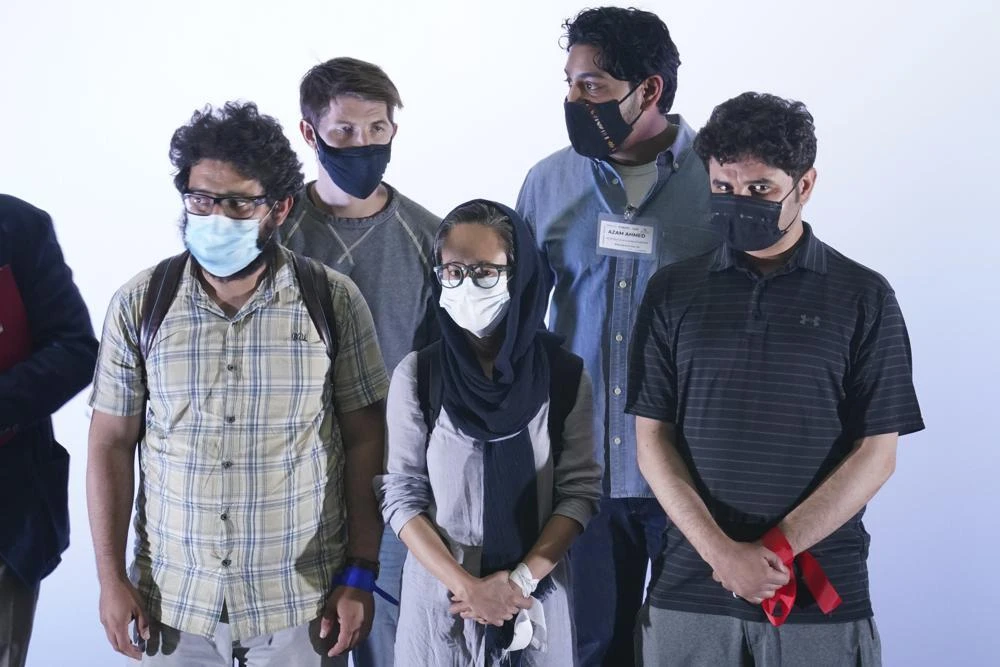 Afghan journalist refugees stand during a welcoming ceremony by Mexican Foreign Minister Marcelo Ebrard upon arrival to Benito Juarez International Airport in Mexico City. (AP)