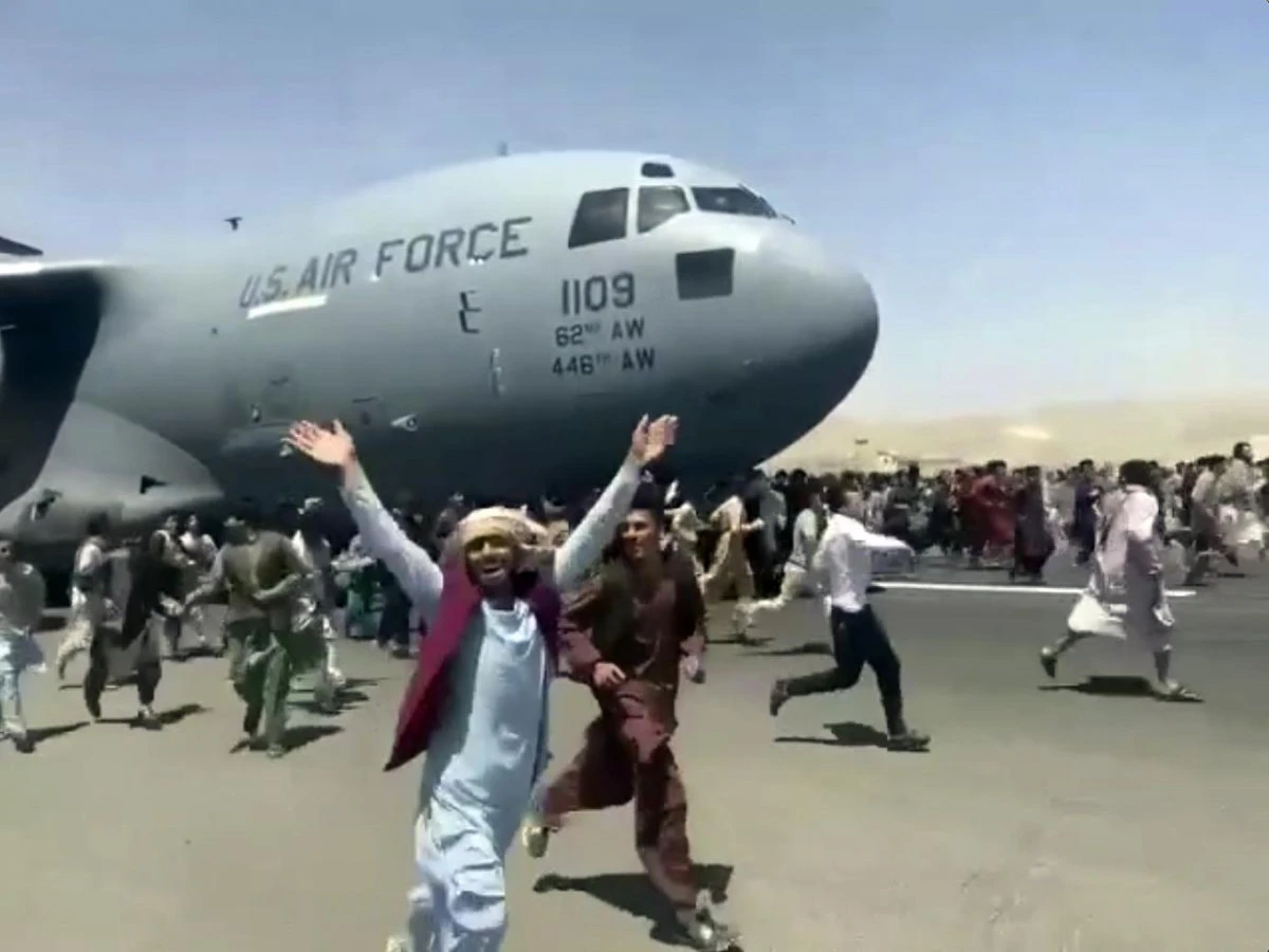 Afghans fleeing the Taliban run in desperation as a US Air Force cargo plane lifts off from Kabul airport. (AFP)