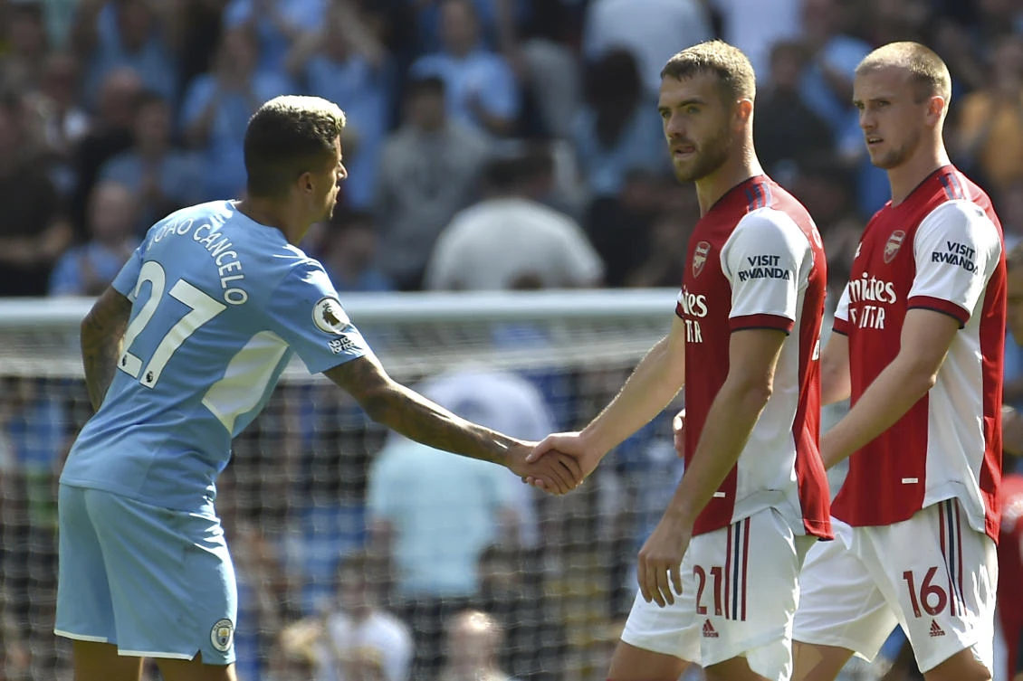 Manchester City’s Joao Cancelo shakes hands with Arsenal’s Calum Chambers after the English Premier League match between Manchester City and Arsenal at Etihad stadium in Manchester on Saturday. (AP)