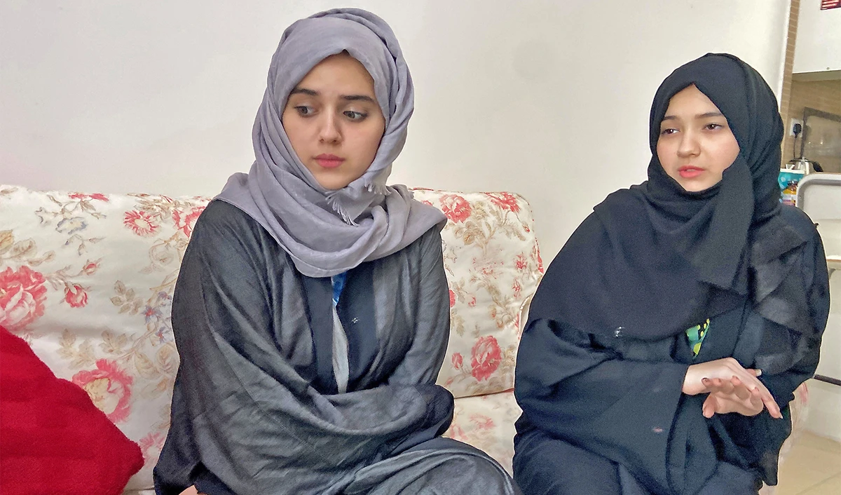 Daughters of Abadat, 35, a woman from Afghanistan, look on at their home in Ajman, United Arab Emirates, on August 29, 2021. (REUTERS)