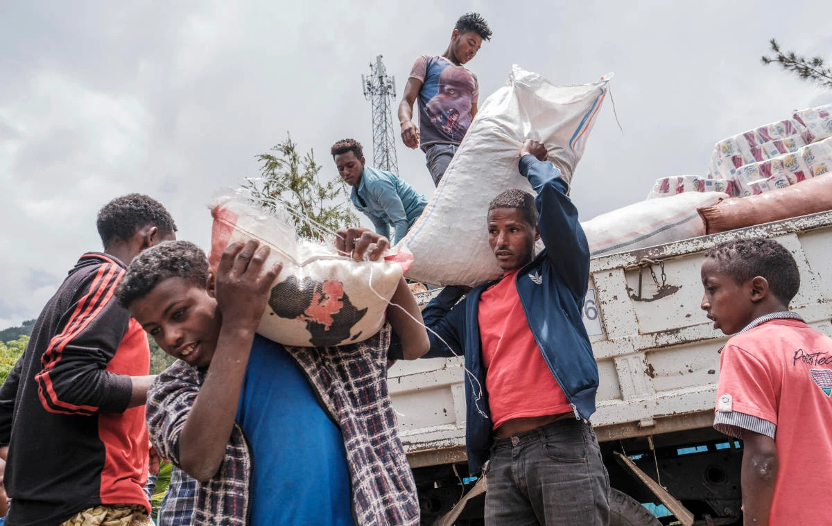 Civilians displaced by fighting in northern Ethiopia offload food and supplies from a truck at a temporary shelter in the city of Dessie. (File/AFP)