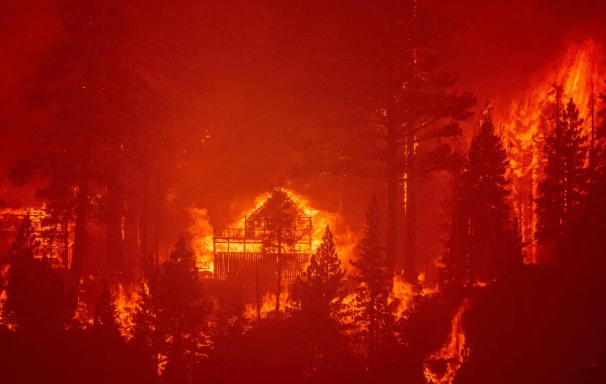 Flames consume multiple homes as the Caldor fire pushes into South Lake Tahoe, California on Aug. 30, 2021. (AFP)
