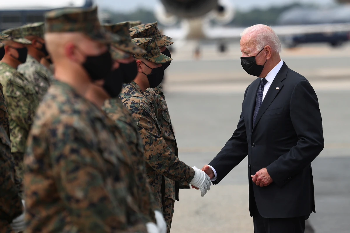 US President Joe Biden shakes hands with a member of the US Marine Corps Honor Guard in Dover, Delaware, August 29, 2021. (Reuters)