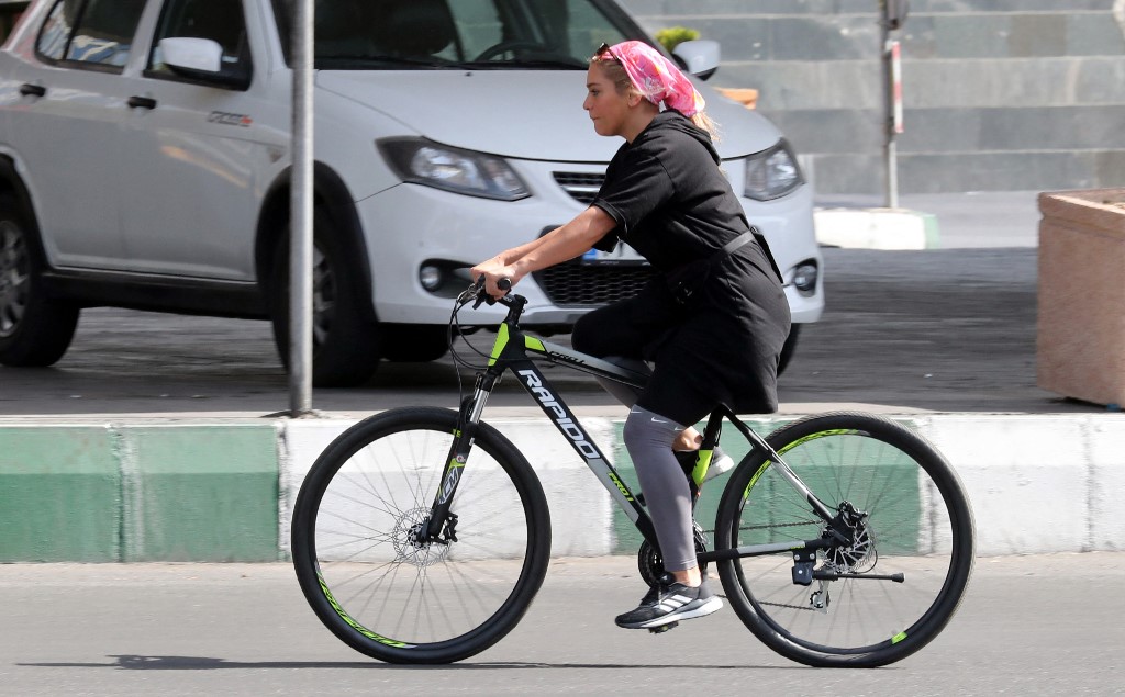 An Iranian woman rides a bicycle during the weekend in the capital Tehran, on September 10, 2021. (AFP)
