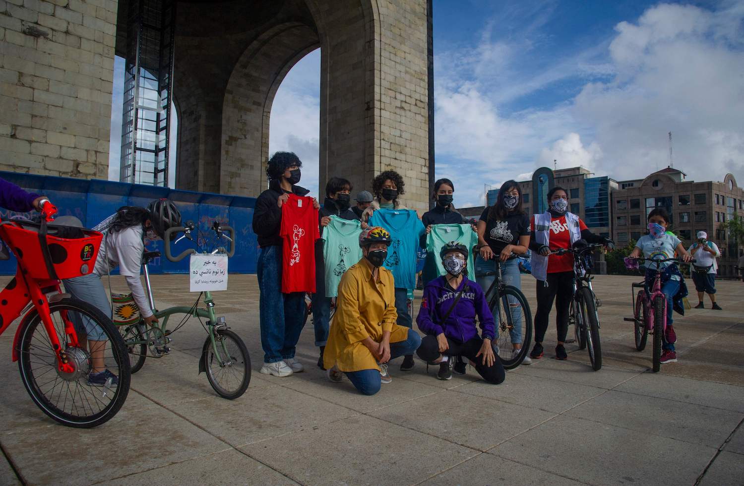 Members of the Afghan robotics team show t-shirts during the bicycle ride 'Mexico las Abraza' welcoming them after receiving asylum from Mexico. (AFP)