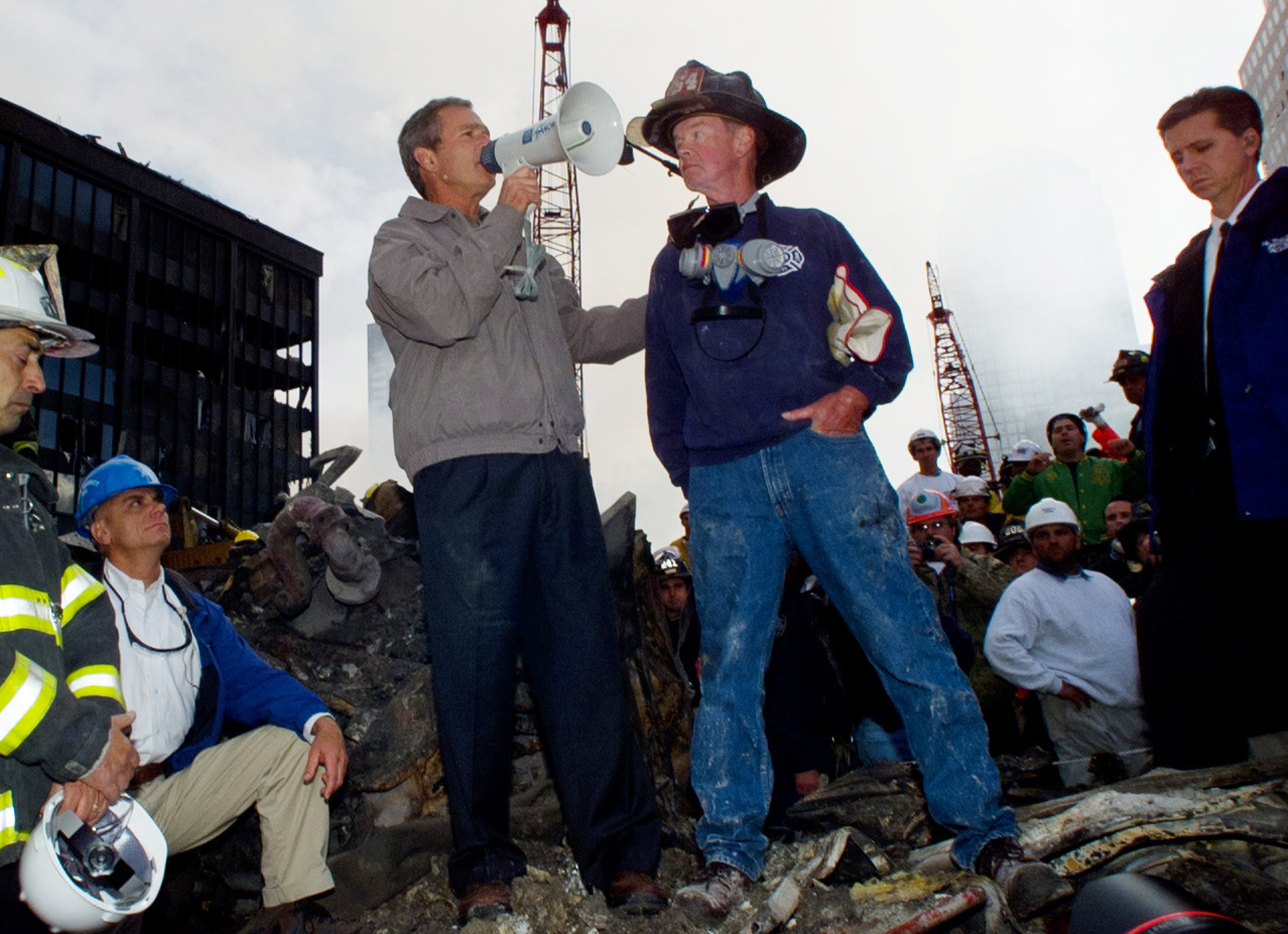 President George Bush stands with firefighter Bob Beckwith on a burnt fire truck in front of the World Trade Center, Friday, Sept. 14, 2001. (AP Photo)
