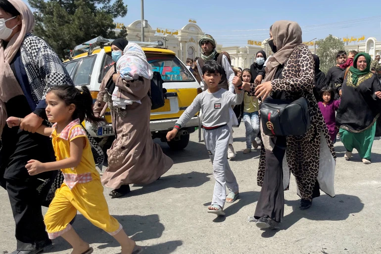 Women and children attempt to gain entry to Kabul airport. (Reuters)