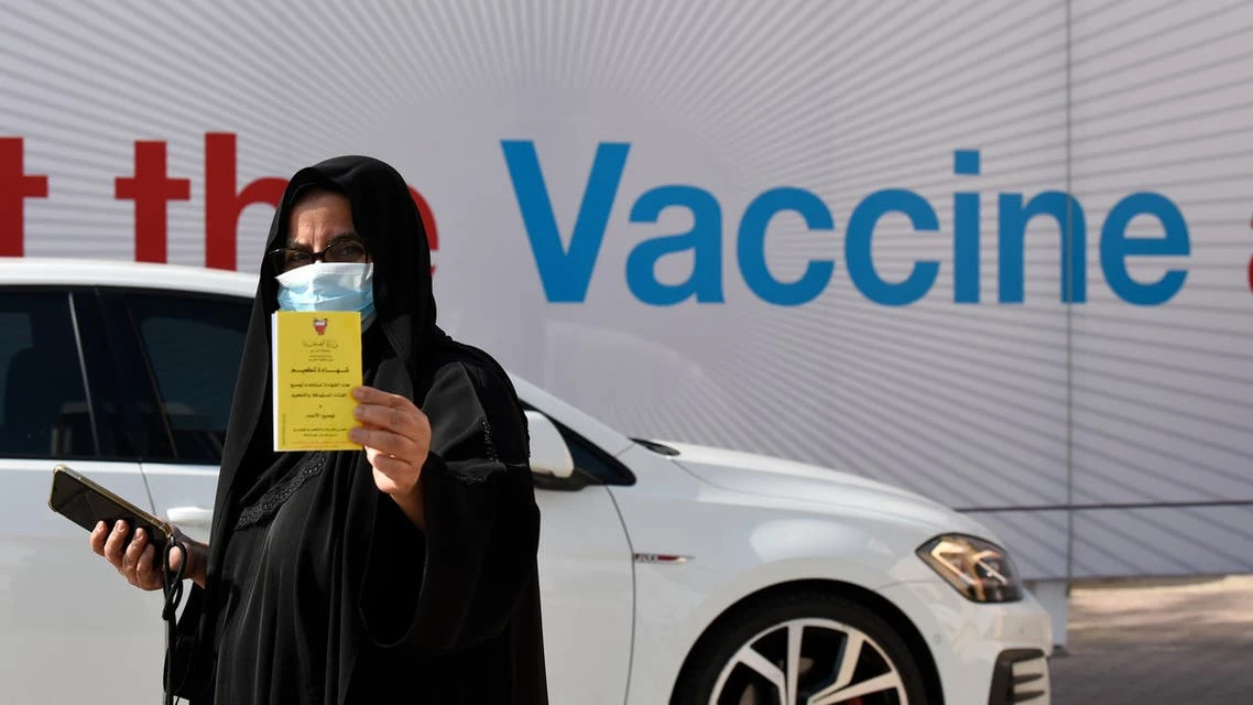 A woman displays her COVID-19 vaccine certificate in front of the Bahrain International Exhibition and Convention Center in the capital Manama, on December 24, 2020. (File photo: AFP)